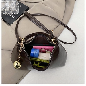 Vue détaillée du sac à bandoulière marron foncé montrant un intérieur spacieux avec accessoires