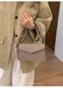 Close-up of khaki corduroy retro bag with a unique knot handle and gold hardware detail