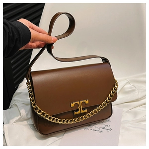 Detail of brown leather crossbody bag with golden chain strap and metallic T-logo buckle