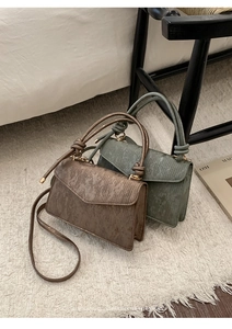 Detail of vintage tote bags in bronze and green with unique brushed texture and gold hardware