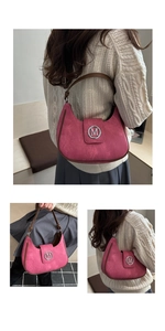 Detail of fuchsia suede moon bag featuring a silver M letter logo and brown leather strap
