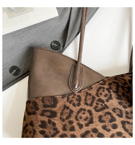 Detail of leopard print suede and brown leather texture on a large tote shoulder bag