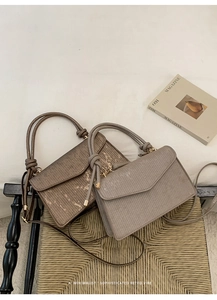 Detail of retro small square handbags in bronze and grey with textured striped finish