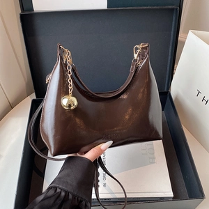 Sac hobo en cuir marron foncé dans sa boîte cadeau avec chaîne dorée à boules