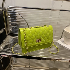 Neon green quilted chain flap bag with golden twist lock on metallic shelf