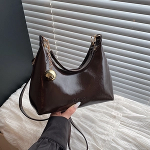 Sac à bandoulière en croissant marron foncé avec charme doré et fini brillant