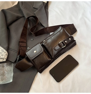 Macro shot of dark brown leather crossbody bag with silver buckles and hardware details