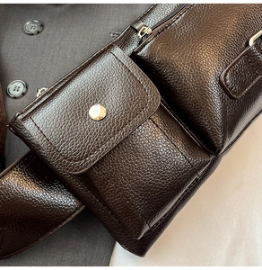 Detailed close-up of dark brown pebble leather bag with metal zippers and stitching