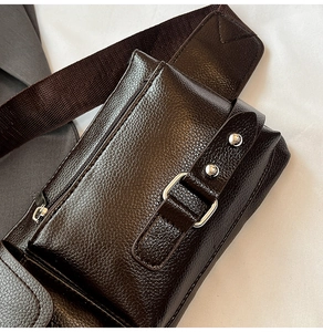 Detail of dark brown lychee leather chest bag with silver metal buckles and nylon strap
