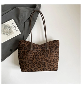 Detail of large leopard print tote bag with brown handles and wool texture