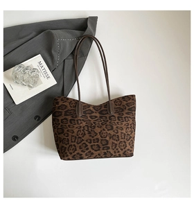 Detailed top view of leopard print tote bag with brown straps on a lifestyle background