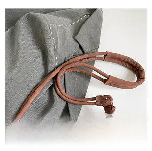 Detail of the thickened round handle on the dark brown suede shoulder bag for extra comfort