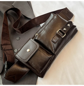Detail of dark brown leather crossbody bag with multiple pockets and metal hardware