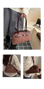 Macro view of brown suede shoulder bag featuring a golden oval buckle and leather handles