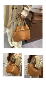 Close-up of brown leather bucket bag featuring a drawstring closure and gold metal lock