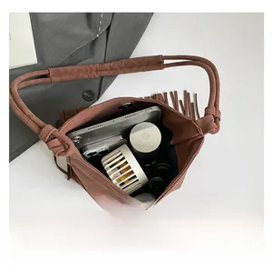 Top view of brown suede ethnic handbag interior showing capacity for phone and cosmetics