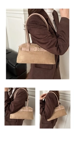 Macro shot of khaki suede tote bag with pink straps and golden decorative buckle