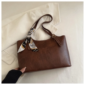 Détail du sac fourre-tout en similicuir marron foncé avec surpiqûres et foulard en soie