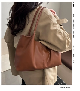 Brown faux leather tote bag showing large capacity and stitching details on a model