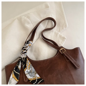 Détail d'un sac cabas marron en PU avec foulard décoratif et boucle en métal doré chic