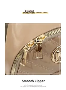 Detail view of smooth golden double zippers and quilted leather texture on a beige bag