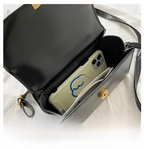 Detailansicht der schwarzen Mini-Ledertasche innen mit Handy und Sonnenbrille