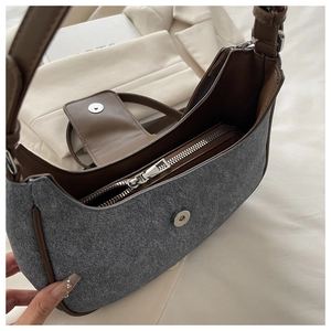 Close-up of the vintage grey fabric underarm bag with brown leather trim and metal zipper