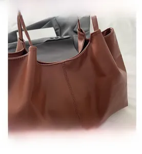 Close-up of brown PU leather tote bag with vertical stitching and fine texture