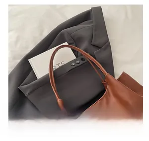 Close-up of comfortable handles and stitching on this brown leather tote bag