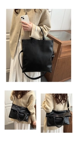 Detail showing black lychee grain leather tote bag with handle and detachable shoulder strap