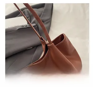 Detail of double stitching on the brown leather tote bag with long shoulder straps