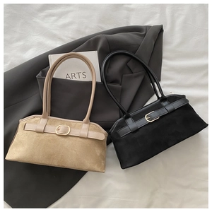 Detailed close-up of khaki and black suede baguette shoulder bags on a minimalist fabric