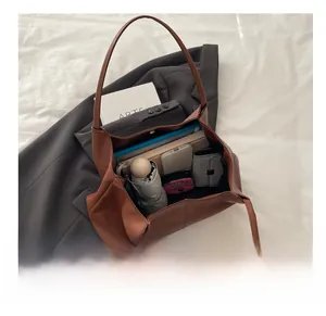 Detail view of the brown leather tote bag interior showing large capacity for daily items