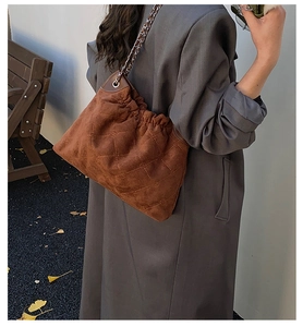 Details der braunen Wildleder-Schultertasche mit Steppmuster und Kettenriemen