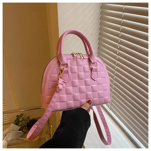 Nahaufnahme der rosa Muschel-Tasche mit detaillierter Schachbrett-Prägetextur