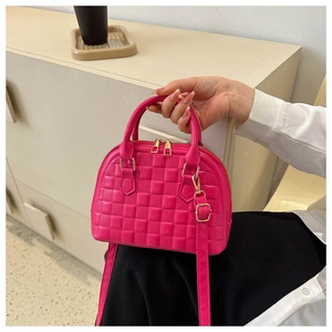 Close-up of rose red textured PU leather handbag with gold zippers and crossbody strap