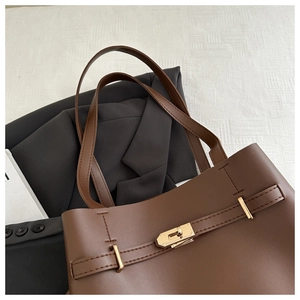 Dettaglio borsa tote in pelle marrone caffè con fibbia dorata e finitura opaca