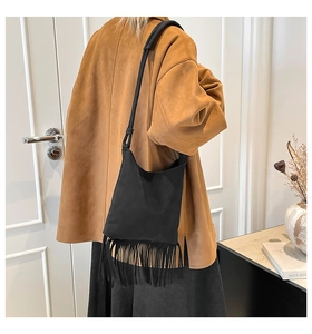 Détail d'un sac à bandoulière en cuir noir avec de longues franges pour un look bohème chic