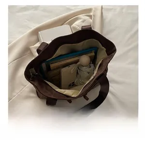 Interior view of large brown tote bag showing capacity for phone, umbrella and books
