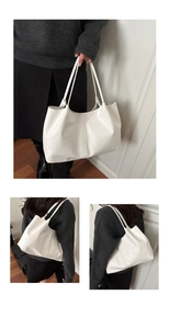 Detail view of large white leather tote bag showing handle attachments and side profile