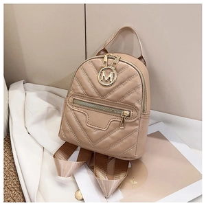 Detail of beige quilted mini backpack with golden M logo on white shirt background