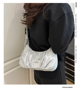 Detail of silver metallic butterfly shoulder bag with trendy pleated fabric texture