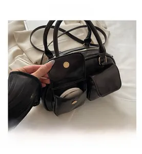 Detail of dual front pockets with gold magnetic snaps on a black retro handbag