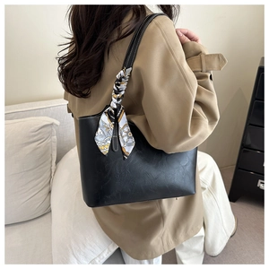 Grand sac cabas noir avec foulard en soie décoratif porté avec un trench-coat chic
