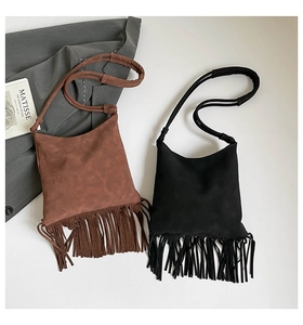 Détail de sacs à bandoulière bohèmes à franges en daim marron et noir avec pompons