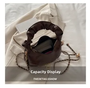 Deep brown ruched handbag interior view showing storage space for phone and cardholder
