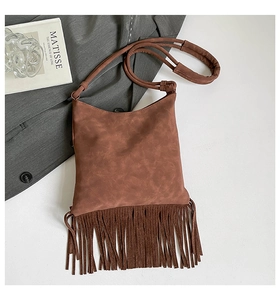 Mise à plat d'un sac bandoulière en daim marron avec de longues franges et un style rétro