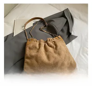 Details der braunen Wildledertasche mit gestepptem Herzmuster und Kettenriemen