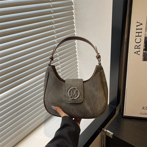 Minimalist grey suede crescent underarm bag with brown leather trim and silver M logo