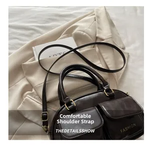 Close-up of vintage coffee brown crossbody bag with double front pockets and gold text